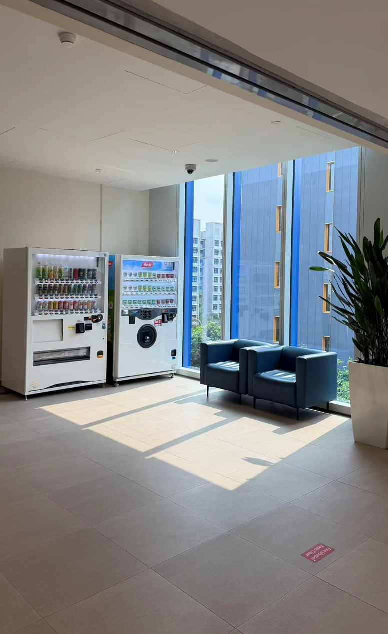 Waiting lounge beside full-height windows, with sunlight falling in patches across the floor